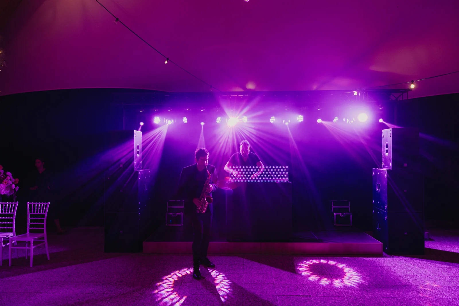 An illuminated dance floor and music setup at an evening event.