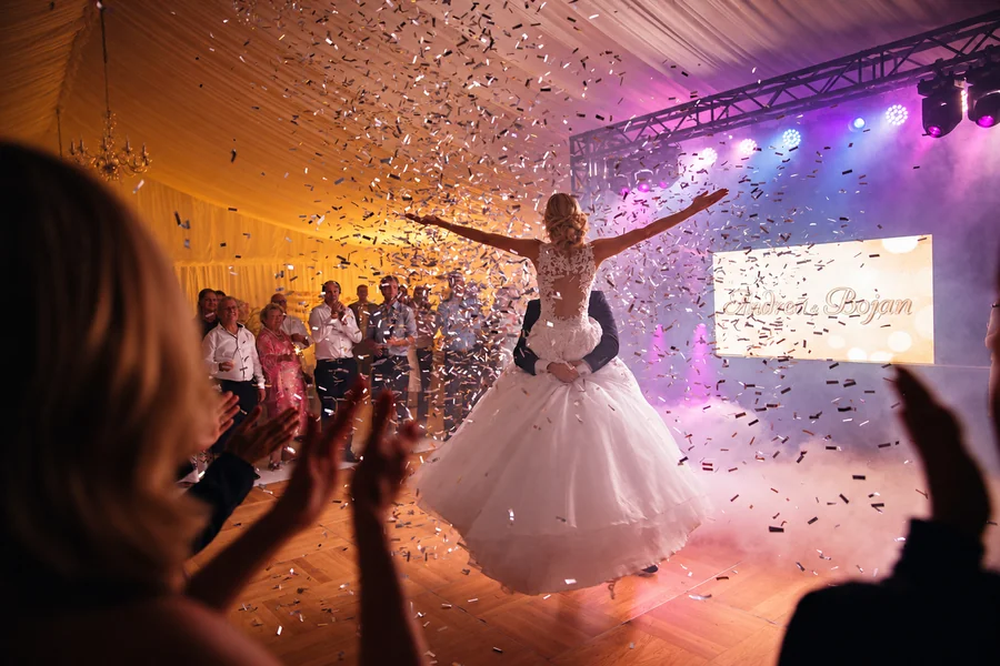 A bride on the dance floor beneath a shower of confetti.