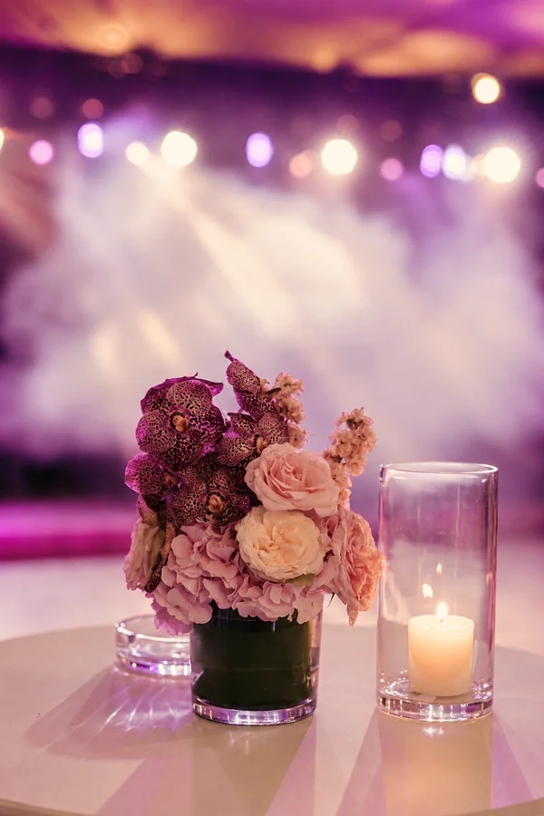 Flowers and candles in front of an illuminated stage.