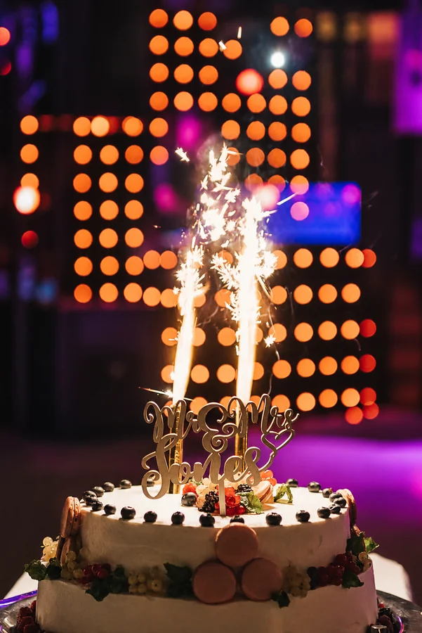 A wedding cake with a glowing sparkler.
