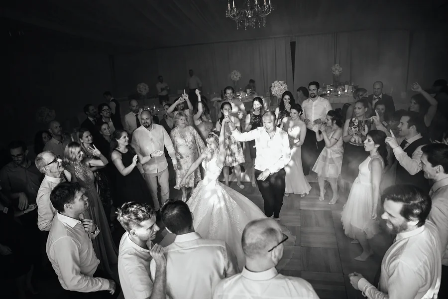 Wedding guests on the dance floor, captured in black and white.