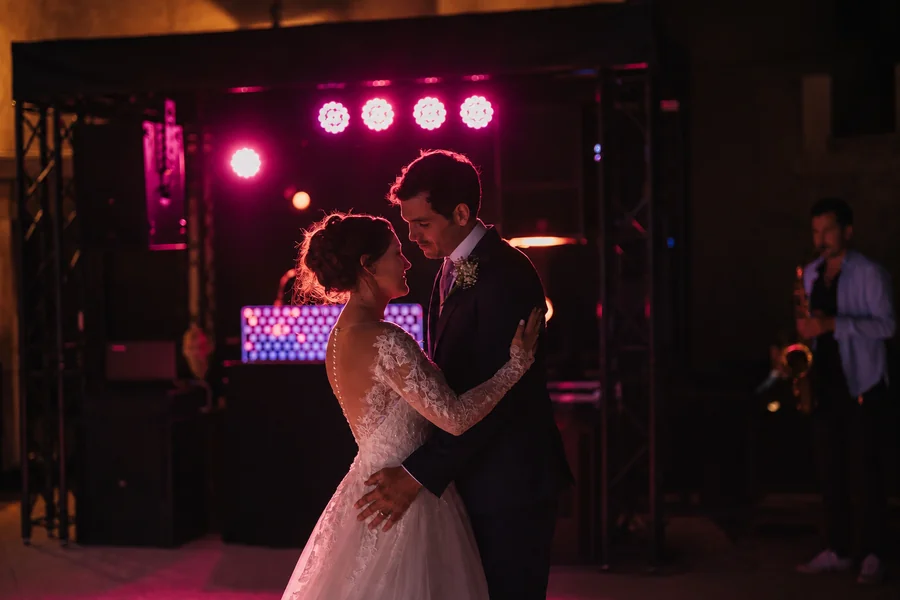 A wedding couple during their first dance under soft evening lighting.
