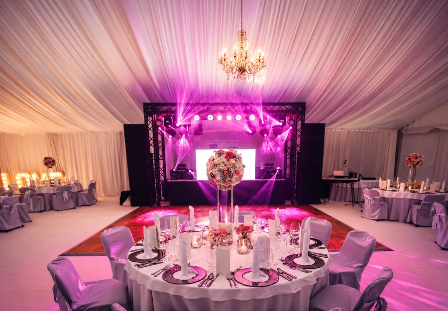 An elegant reception with dressed tables and evening lighting.