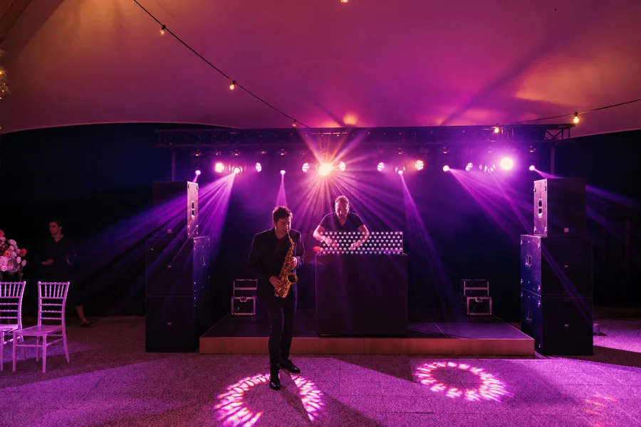 An illuminated dance floor and music setup at an evening event.